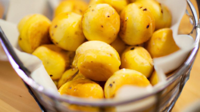 Imagem de uma tigela branca cheia de polenta crocante e dourada em forma de palitos, servida com um molho vermelho ao lado.