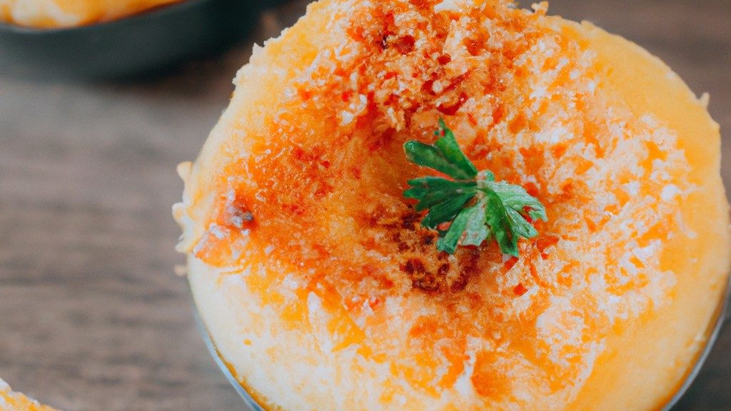 Imagem de um pudim fit assado em uma airfryer. O pudim é feito com ingredientes saudáveis, como aveia, banana e cacau em pó, e é coberto com uma calda de chocolate saudável.