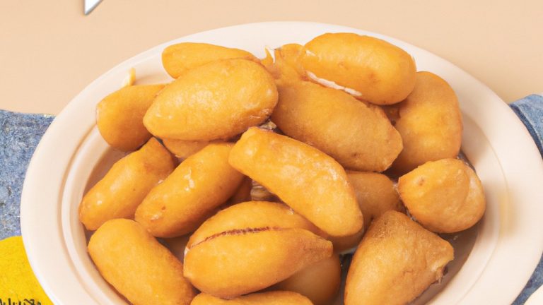 Uma foto de almôndegas douradas e crocantes cozidas em uma Airfryer. As almôndegas são feitas com carne moída, pão ralado, ovo, cebola e especiarias e têm um molho vermelho espesso.