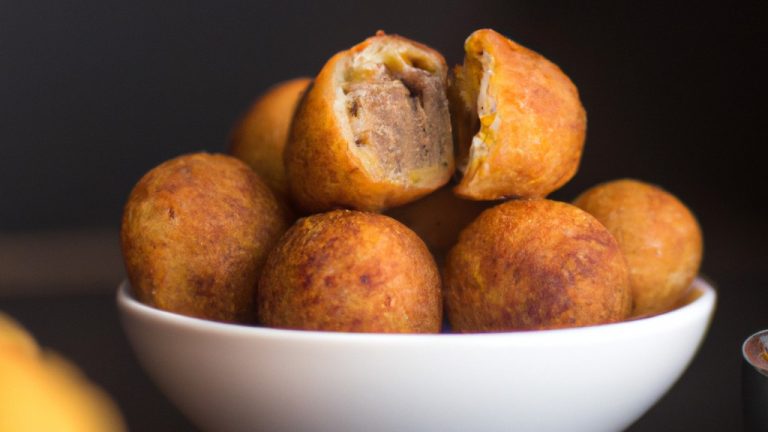 Uma foto de cima para baixo de um bolinho de batata-doce redondo e dourado em cima de uma tábua de cortar de madeira. O bolinho é coberto com carne moída dourada e temperada e cebolas vermelhas picadas.