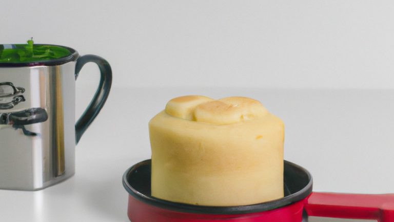Imagem de um bolo de caneca cozido na Airfryer, com cobertura de chocolate e granulado colorido. O bolo é fofo e dourado, e a cobertura está derretida e brilhante.