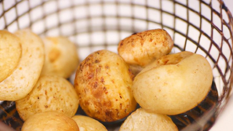 Imagem de um prato com coquinhos açucarados dourados e crocantes, preparados na Airfryer. O prato é acompanhado por um copo de leite para mergulhar os coquinhos.