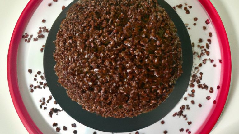 Foto de um grande bolo de brigadeiro cozido em uma fritadeira elétrica. O bolo é marrom escuro e coberto com uma camada de brigadeiro cremoso.
