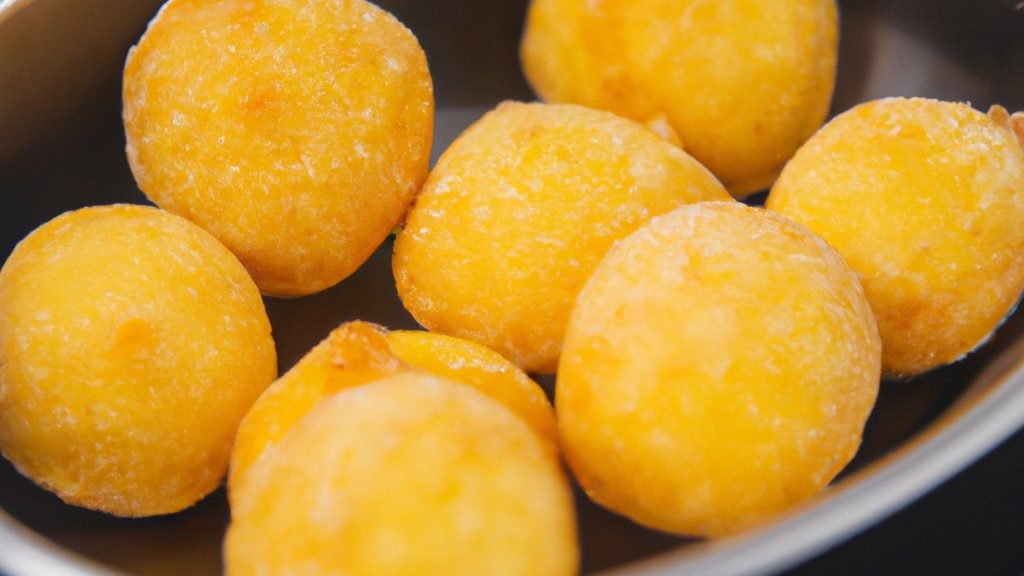 Imagem de medalhões de batata bolinha recheados cozidos em uma Airfryer. Os medalhões são crocantes por fora e macios por dentro, recheados com uma mistura cremosa de queijo, ervas e temperos.