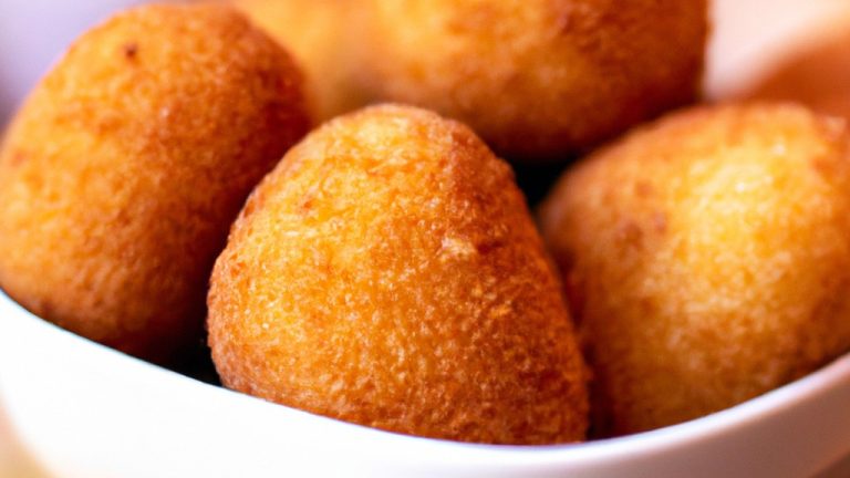 Imagem de uma porção de torresmo crocante e dourado em um prato branco. Eles são feitos com fatias finas de barriga de porco e cozidos na Airfryer, resultando em uma textura crocante e saborosa.