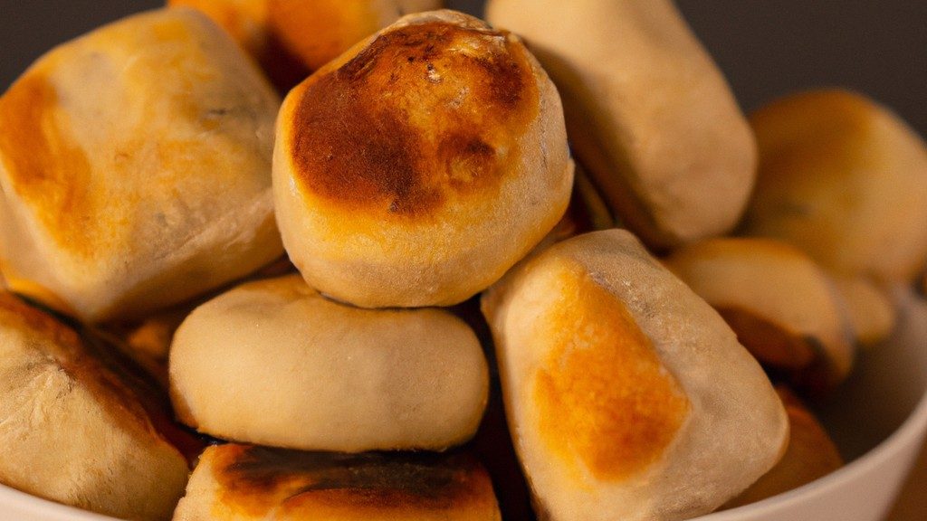 Foto de esfihas de batata-doce cozidas em uma airfryer, com recheio visível e crosta dourada.