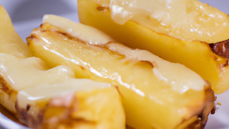 Imagem de uma batata gratinada dourada e crocante cozida em uma Airfryer. O prato é coberto com queijo derretido e ervas frescas, e está servido em um prato branco.
