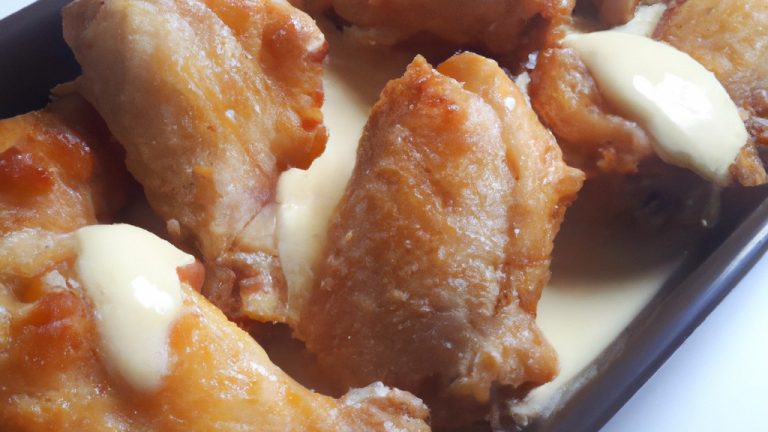 Imagem de um frango inteiro cozido em uma Airfryer, coberto com um molho cremoso e dourado.