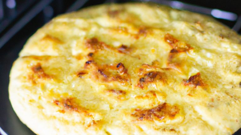 Imagem de uma torta de abobrinha assada em uma Airfryer. A torta tem uma crosta dourada e é recheada com abobrinha ralada, queijo, ervas e especiarias.