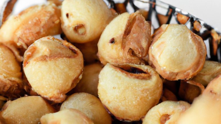Imagem de Rondelis recém-fritos feitos na airfryer. Os Rondelis são dourados e crocantes, com recheio de queijo derretido escorrendo. Eles estão dispostos em um prato com um molho de tomate ao lado.