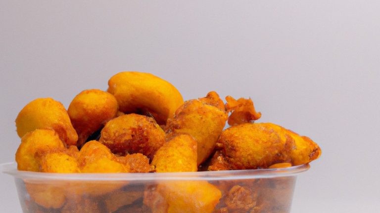 Imagem de um prato com mandioquinhas cortadas em palitos douradas e crocantes. A mandioquinha está disposta em formato de pirâmide e é acompanhada por um molho de tomate.
