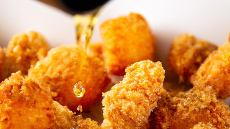 Imagem de uma sobrecoxa de frango assada em uma airfryer, coberta com queijo parmesão ralado. A sobrecoxa é mostrada em cima de uma superfície escura, com gotas de gordura escorrendo pela lateral.