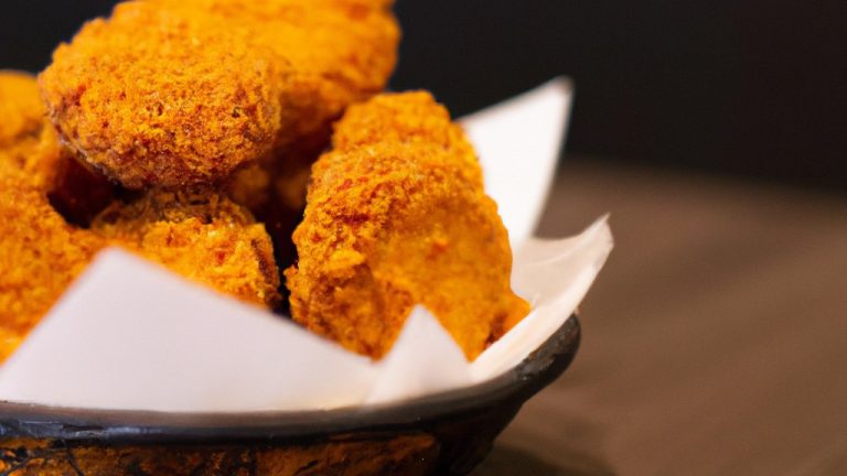 Imagem de uma sobrecoxa de frango crocante e dourada cozida em uma Airfryer. A sobrecoxa é temperada com sal, pimenta e páprica.