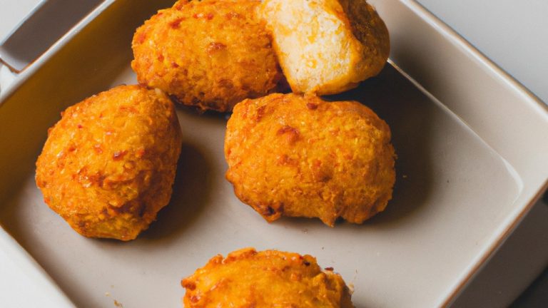 Imagem de uma sobrecoxa de frango recheada com farofa, bacon e queijo, cozida em uma airfryer. O frango está dourado e crocante, com a farofa saltitante e o queijo derretido borbulhando por cima.