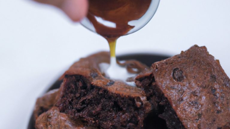 Imagem de um brownie de chocolate rico e decadente feito em uma airfryer. O brownie tem uma crosta crocante e um interior macio e fudgy. É coberto com uma camada de glacê de chocolate e polvilhado com nozes picadas.