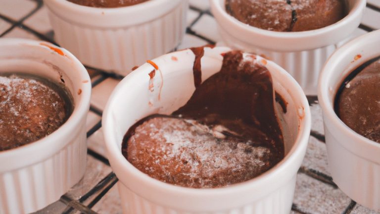Imagem de um suflê de chocolate feito na Airfryer. O suflê é marrom dourado e tem uma textura arejada. É servido em uma tigela branca com uma colher.