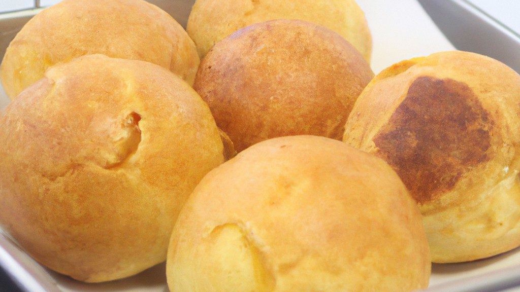 Imagem de um suflê de chuchu assado na Airfryer, com uma crosta dourada e fofa. A imagem mostra o suflê cortado ao meio, revelando seu interior cremoso e fofo.