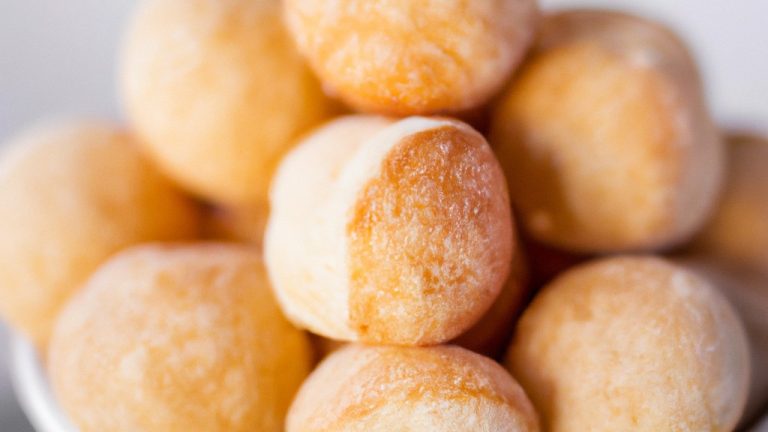 Imagem de uma tigela de tapioca cozida em uma airfryer. A tapioca é branca e tem uma textura crocante. A tigela está sobre uma superfície de madeira escura.