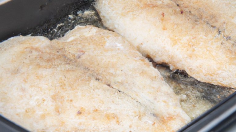 Uma tilápia inteira congelada em uma airfryer, mostrando sua pele dourada e crocante. A tilápia é colocada sobre uma cama de limão e ervas, e está pronta para ser servida.