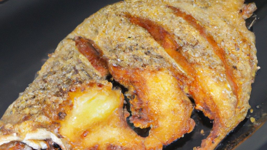 Tilápia crocante preparada na airfryer, com pele dourada e crocante destacando-se do filé branco macio e suculento. A textura contrastante cria uma experiência gastronômica deliciosa.