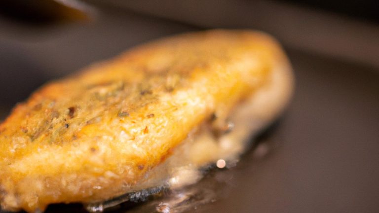 Imagem de tilápia frita na Airfryer, com manteiga derretida por cima. A tilápia é dourada e crocante, com um interior branco e escamoso.
