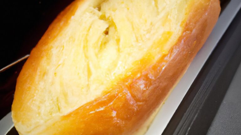 Imagem de uma torrada de pão francês dourada e crocante cozida em uma Airfryer. A torrada é polvilhada com açúcar de confeiteiro e servida com frutas frescas e xarope de bordo.