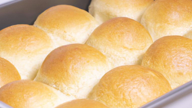 Imagem de uma cesta de Airfryer cheia de torradas de pão sírio crocantes e douradas, dispostas em camadas com queijo derretido, tomate fatiado e ervas frescas.