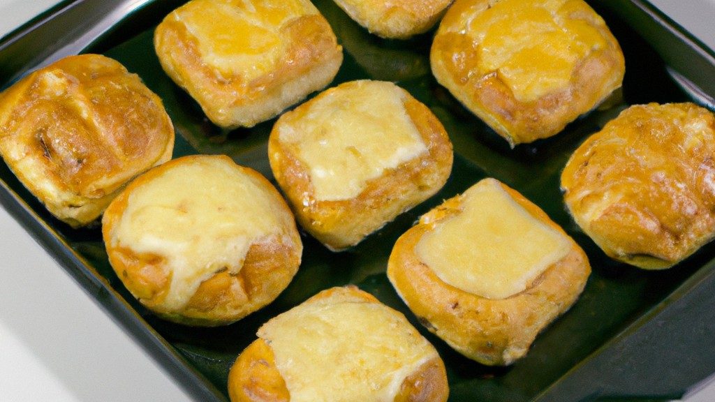 Imagem de torradinhas douradas e crocantes preparadas na airfryer, servidas em um prato branco. As torradinhas são polvilhadas com sal e pimenta e têm um toque de manteiga derretida.