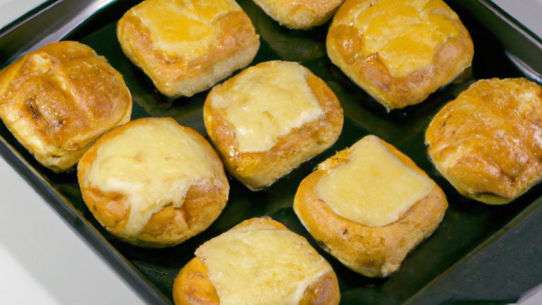 Imagem de torradinhas douradas e crocantes preparadas na airfryer, servidas em um prato branco. As torradinhas são polvilhadas com sal e pimenta e têm um toque de manteiga derretida.