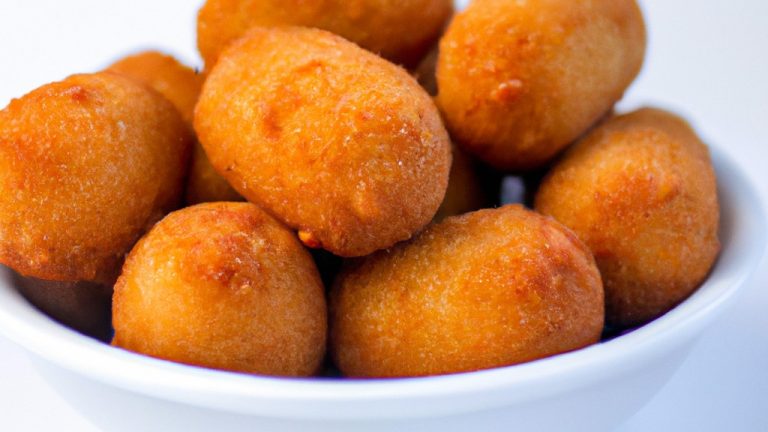 Imagem de uma air fryer Philips branca com um cesto de cozimento preto removível. A air fryer está em cima de uma bancada de cozinha de granito cinza com uma tigela de metal cheia de batatas fritas ao lado. No fundo, há uma parede branca com uma janela que mostra árvores e um céu azul.