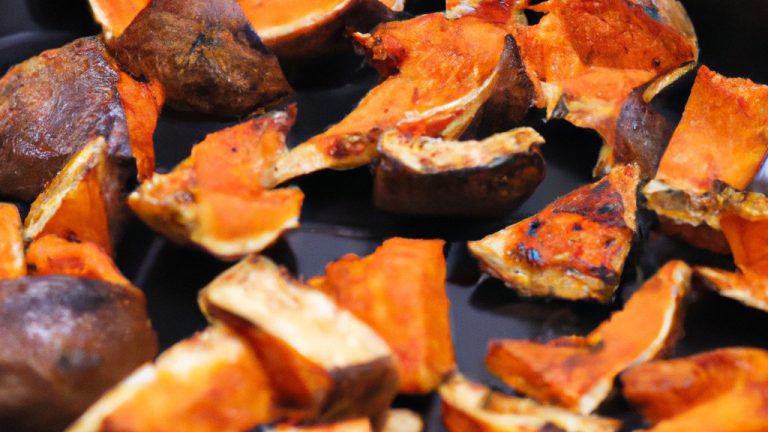Imagem de uma abóbora assada na Airfryer. A abóbora é cortada ao meio e assada com azeite, sal e pimenta. A abóbora tem uma pele crocante e um interior macio e amanteigado.
