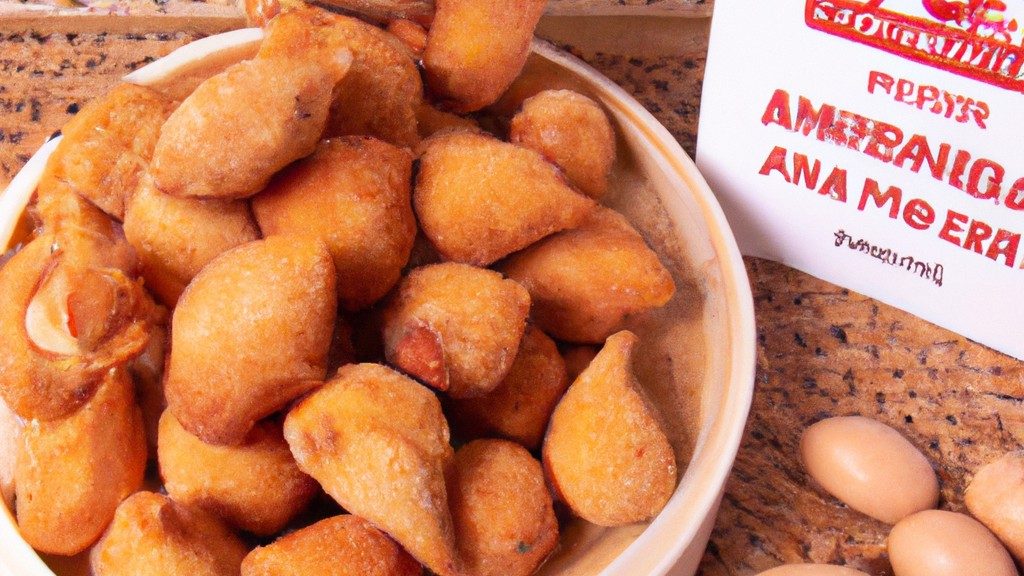 Imagem de almôndegas de frango crocantes e douradas cozidas na Airfryer, servidas em um prato com um acompanhamento de molho de tomate.