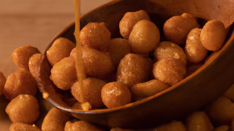 Imagem de amendoins torrados e crocantes cobertos com uma camada doce e picante de mostarda e mel. Os amendoins estão dispostos em uma tigela de servir, prontos para serem saboreados.