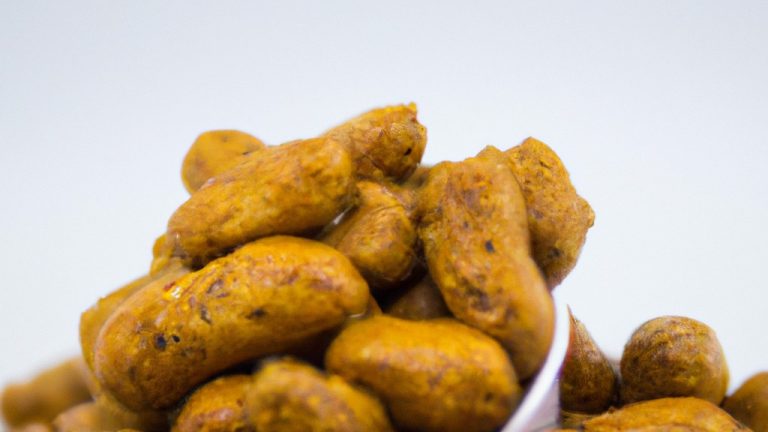 Imagem de uma tigela de amendoim torrados e temperados preparados na Airfryer. Os amendoins são castanhos dourados e têm uma crosta ligeiramente crocante. Estão polvilhados com sal e pimenta, e têm um aroma salgado e noz.