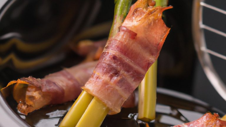 Uma imagem de aspargos verdes brilhantes e bacon crocante cozidos em uma airfryer. Os aspargos são longos e finos, com pontas tenras. O bacon está cortado em fatias finas e enrolado em torno dos aspargos. A imagem é nítida e vibrante, e o fundo é branco.