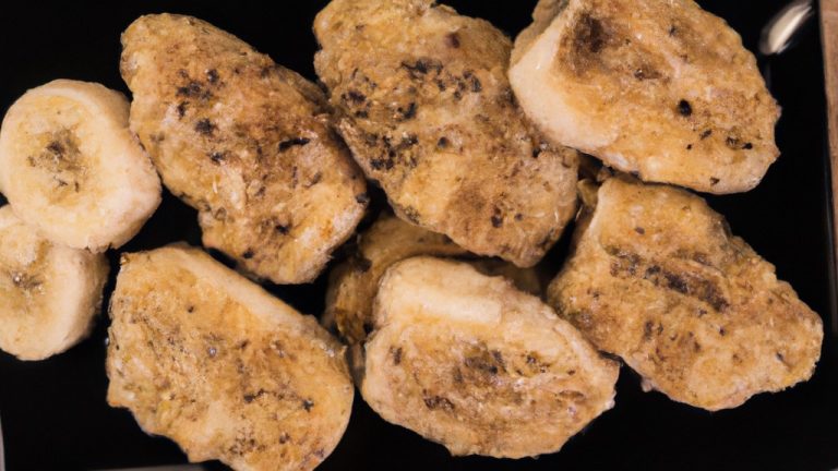 Imagem de banana à milanesa na airfryer, com cobertura crocante e dourada, servida em um prato com folhas de hortelã como decoração.