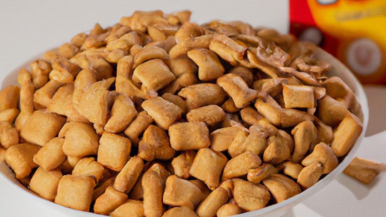 Barrinhas de cereal crocantes e douradas feitas na Airfryer. As barrinhas são cortadas em pedaços quadrados, revelando seu interior dourado e crocante. O fundo da imagem mostra a Airfryer usada para fazer as barrinhas, com sua cesta de cozimento removível.