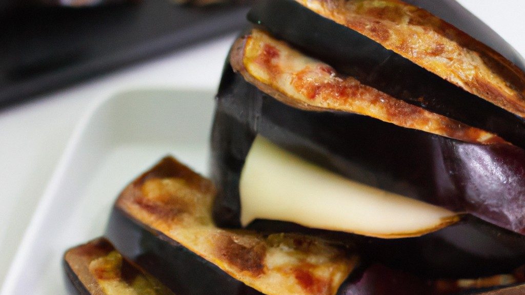 Imagem de uma torre de berinjela assada na airfryer, empilhada com camadas de queijo parmesão derretido, molho de tomate e folhas de manjericão. A torre está apoiada em uma superfície de madeira, com um fundo desfocado de utensílios de cozinha.