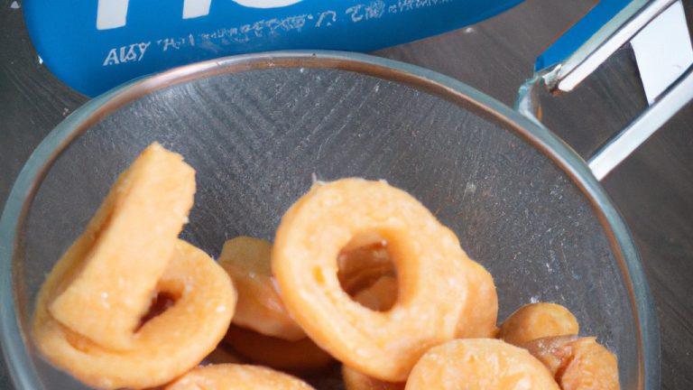 Imagem de biscoitinhos dourados e crocantes feitos com leite condensado, cozidos em uma airfryer. Eles são dispostos em uma cesta de ar quente com uma camada crocante no topo e um interior macio e derretido.