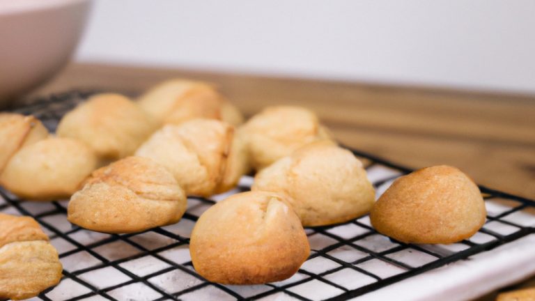 Uma imagem de bolinhos de cookie dourados e crocantes recém-saídos de uma Airfryer. Os bolinhos são cobertos com gotas de chocolate e estão dispostos em um prato branco.