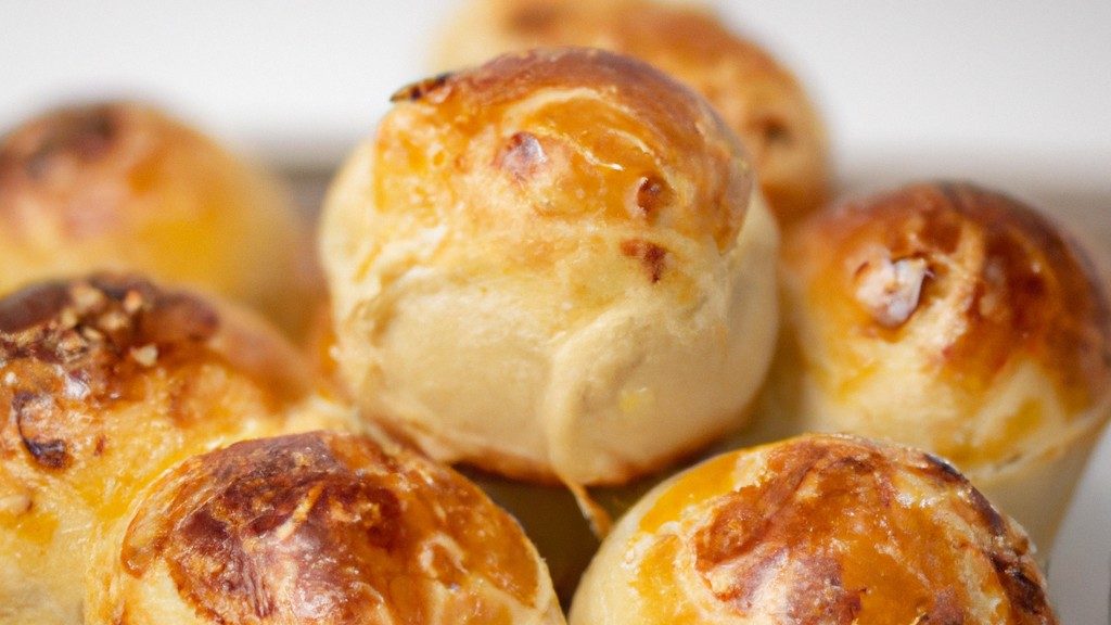 Imagem de um pão brioche dourado e fofo em uma airfryer. O pão é redondo, com uma crosta crocante e um interior macio e arejado. A airfryer é preta e tem uma cesta de metal.