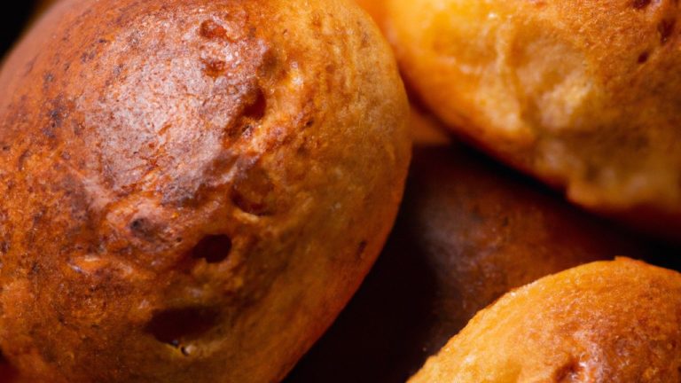 Imagem de broas de fubá crocantes e douradas fritas em uma airfryer. As broas são feitas com farinha de milho, leite, ovos e açúcar, e têm uma textura macia por dentro e crocante por fora.