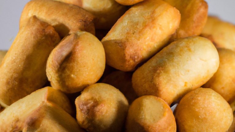 Imagem de canudinhos recheados dourados e crocantes preparados na Airfryer. Acompanhados por um pote de molho para mergulhar.