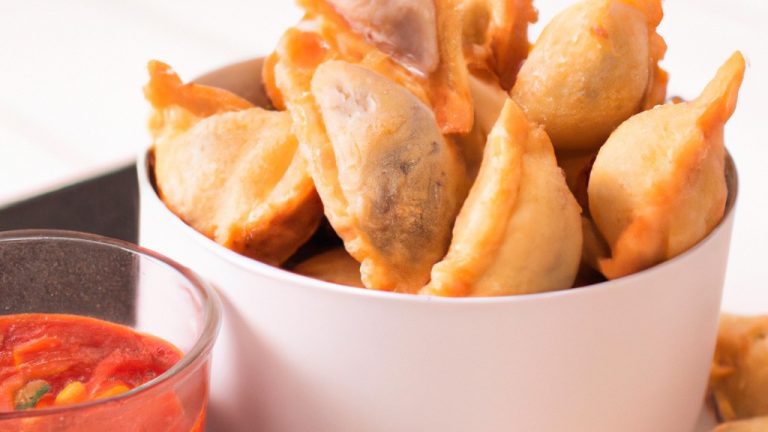 Imagem de Capeletti ou Ravioli fritos na Airfryer, crocantes e dourados, servidos em um prato com molho de tomate.
