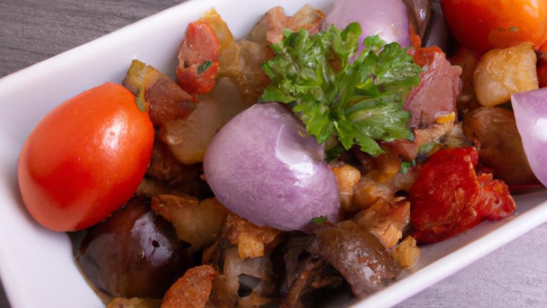 Imagem de uma travessa cheia de Caponata Antepasto feita na Airfryer. A Caponata é uma mistura de berinjela em cubos, pimentão, cebola, aipo e azeitonas pretas. É coberto com uma crosta crocante de pão ralado e queijo parmesão. O prato é servido com pão torrado ou biscoitos.