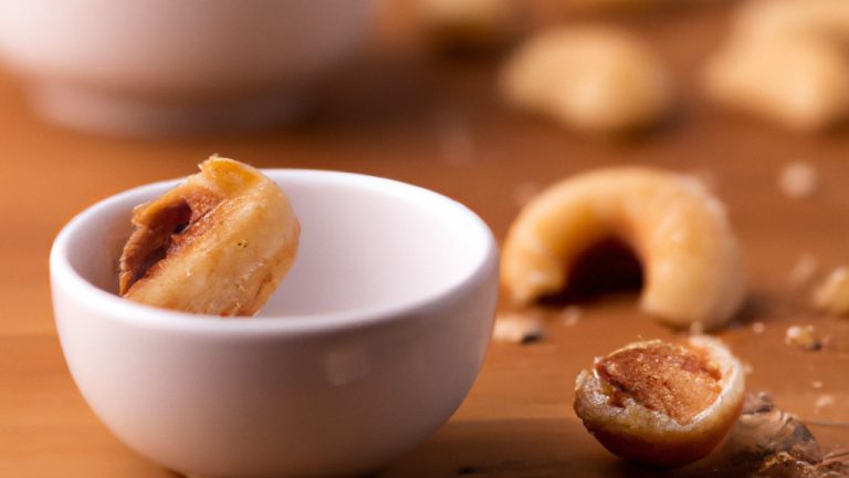 Imagem de castanhas doces caramelizadas em uma tigela, polvilhadas com canela e açúcar de confeiteiro.