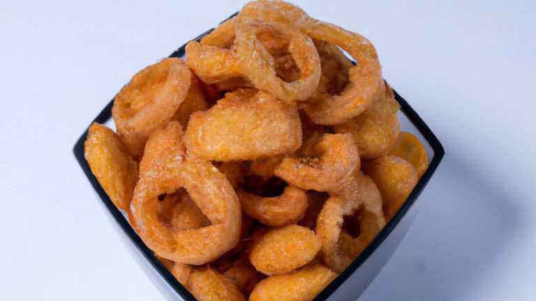 Imagem de cebolas fritas crocantes feitas em uma Airfryer. As cebolas são douradas e crocantes, e estão dispostas em uma tigela.