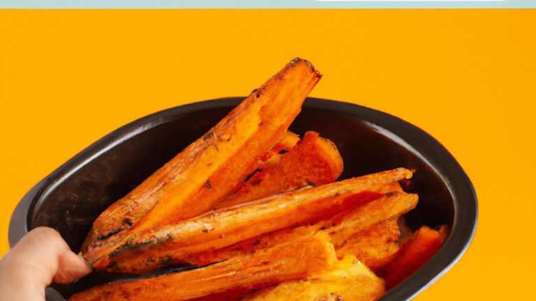 Cenouras crocantes e caramelizadas grelhadas na Airfryer, organizadas em um prato branco. As cenouras têm bordas douradas e são cobertas com alecrim fresco picado.