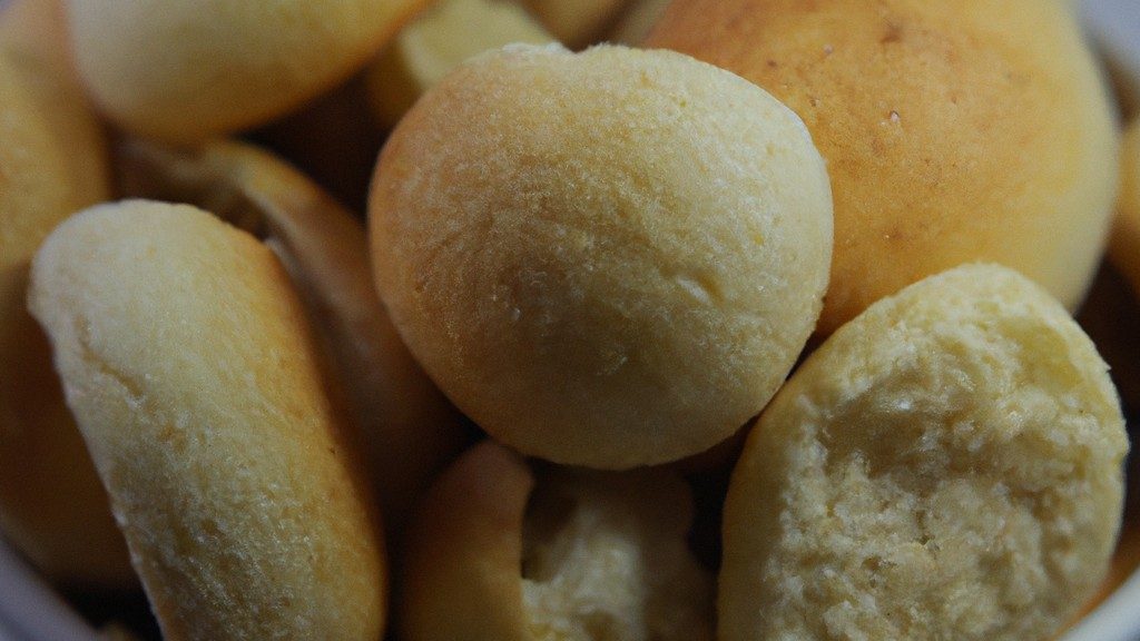 Imagem de uma cesta de Airfryer cheia de Chipas, um pãozinho de queijo brasileiro, recém-assados e dourados. Eles estão dispostos em camadas, mostrando sua textura crocante e interior macio. A imagem transmite o aroma e o calor do pão recém-assado.