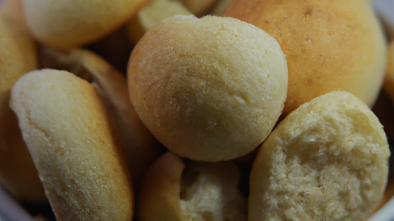 Imagem de uma cesta de Airfryer cheia de Chipas, um pãozinho de queijo brasileiro, recém-assados e dourados. Eles estão dispostos em camadas, mostrando sua textura crocante e interior macio. A imagem transmite o aroma e o calor do pão recém-assado.